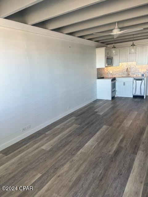 interior space featuring beam ceiling, white cabinetry, stainless steel appliances, and dark hardwood / wood-style floors