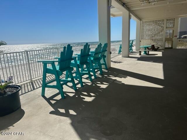 view of patio / terrace with a water view and a beach view