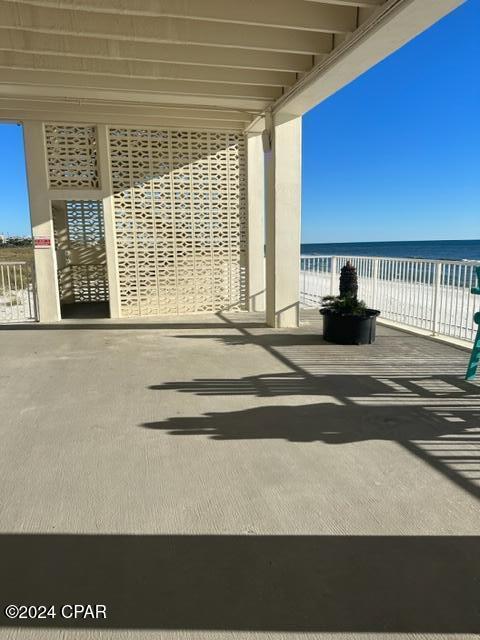 view of patio with a water view and a view of the beach