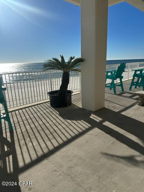 balcony with a water view and a view of the beach