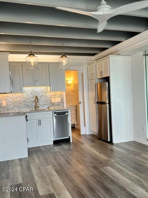 kitchen featuring pendant lighting, backsplash, white cabinets, appliances with stainless steel finishes, and wood-type flooring