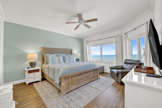 bedroom featuring a water view, light hardwood / wood-style flooring, ceiling fan, and ornamental molding