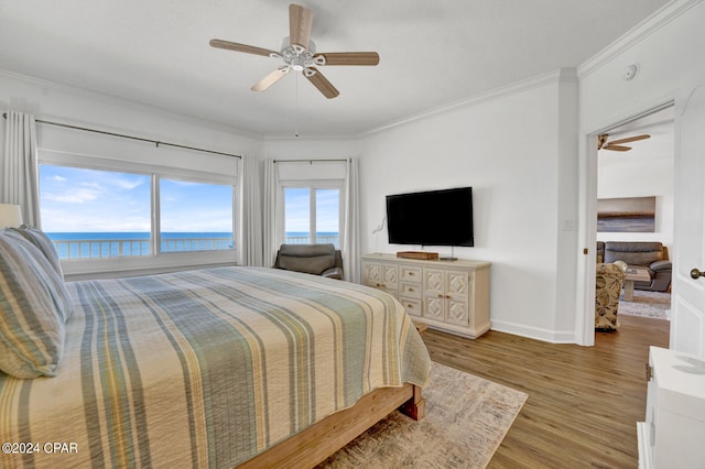 bedroom featuring crown molding, a water view, ceiling fan, and light wood-type flooring