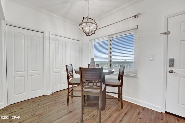 dining room with ornamental molding, an inviting chandelier, and light hardwood / wood-style flooring