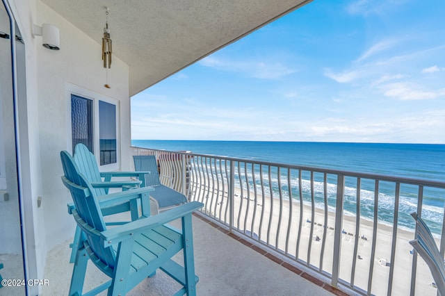 balcony featuring a water view and a beach view