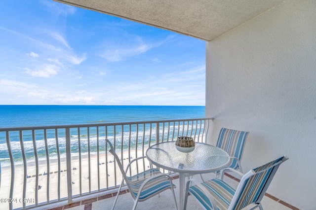 balcony featuring a beach view and a water view