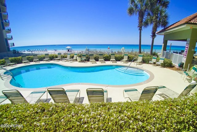 view of swimming pool with a water view and a patio