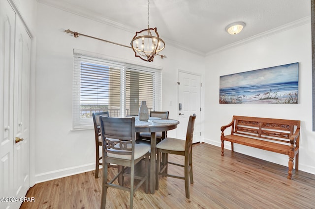 dining space with ornamental molding, a chandelier, and light wood-type flooring