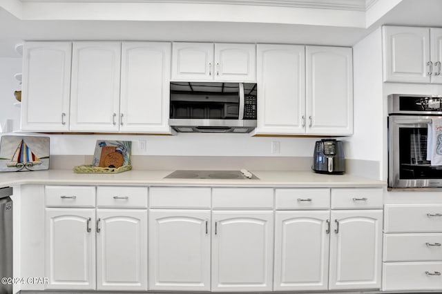 kitchen featuring white cabinets, stainless steel appliances, and ornamental molding