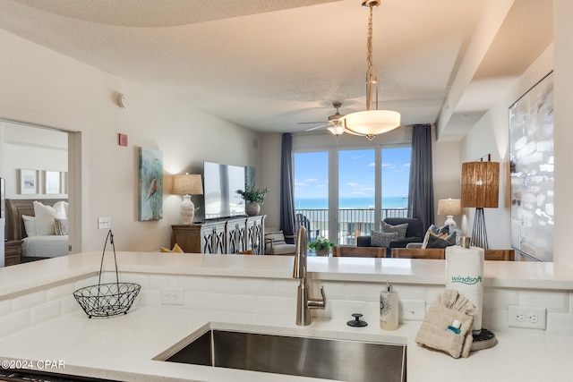 kitchen featuring a textured ceiling, sink, and ceiling fan