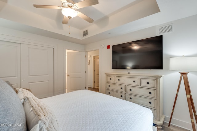 bedroom featuring light hardwood / wood-style flooring, ceiling fan, and a closet