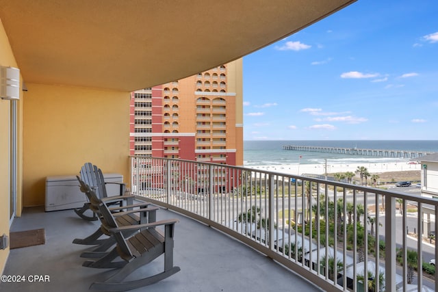 balcony featuring a water view and a beach view