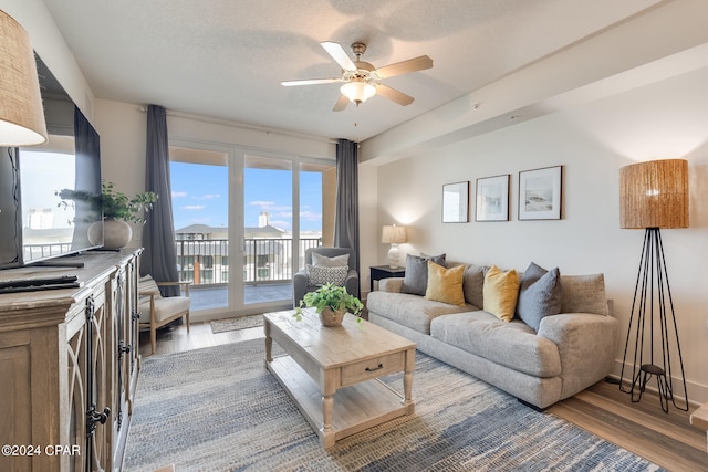 living room featuring a textured ceiling, ceiling fan, and hardwood / wood-style floors