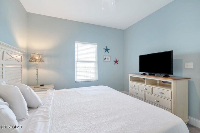 bedroom featuring dark carpet, a closet, and ceiling fan