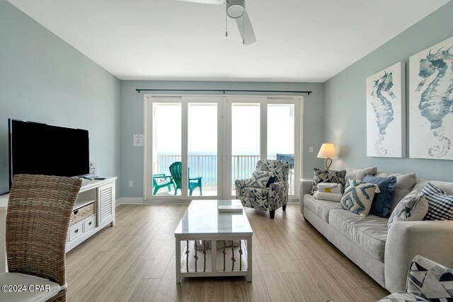 living room with light hardwood / wood-style flooring and ceiling fan