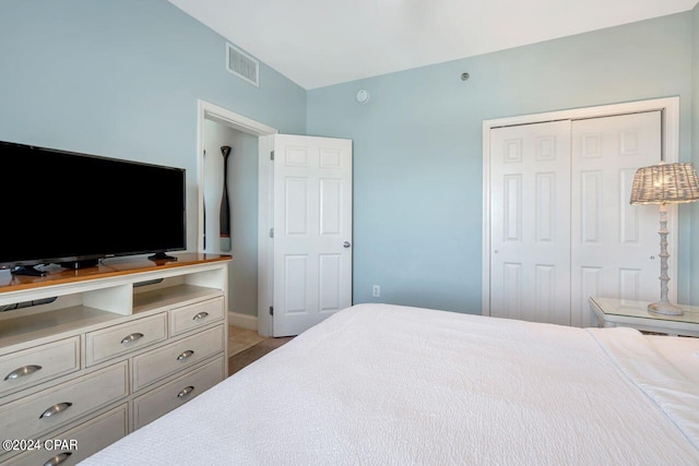 bedroom with vaulted ceiling and a closet