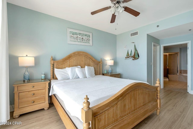 bedroom with ensuite bathroom, light hardwood / wood-style floors, and ceiling fan