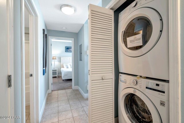 washroom featuring light tile patterned floors and stacked washer / drying machine