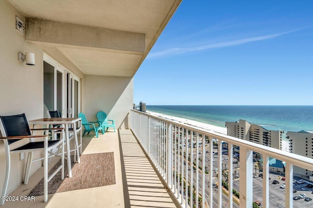 balcony featuring a water view and a beach view