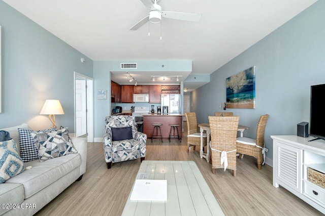 living room with ceiling fan and light hardwood / wood-style floors