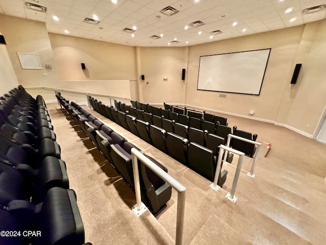 cinema with a paneled ceiling and light colored carpet