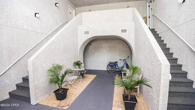 doorway to property with visible vents and stucco siding