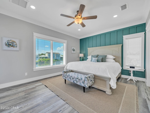 bedroom featuring light wood-type flooring, ceiling fan, and ornamental molding