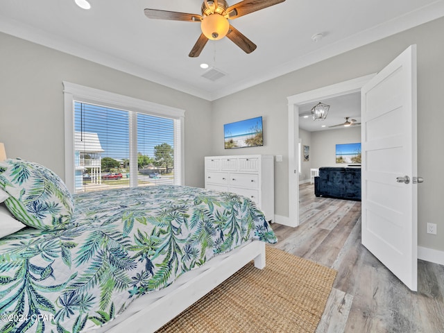 bedroom with light hardwood / wood-style flooring, ceiling fan, and crown molding