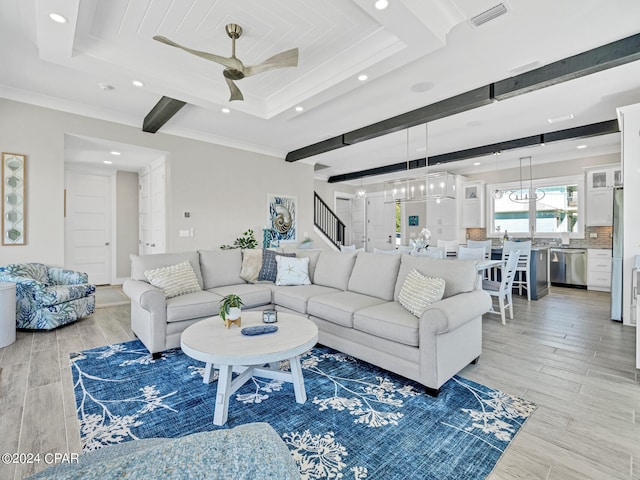 living room featuring light hardwood / wood-style floors, crown molding, ceiling fan, and a tray ceiling