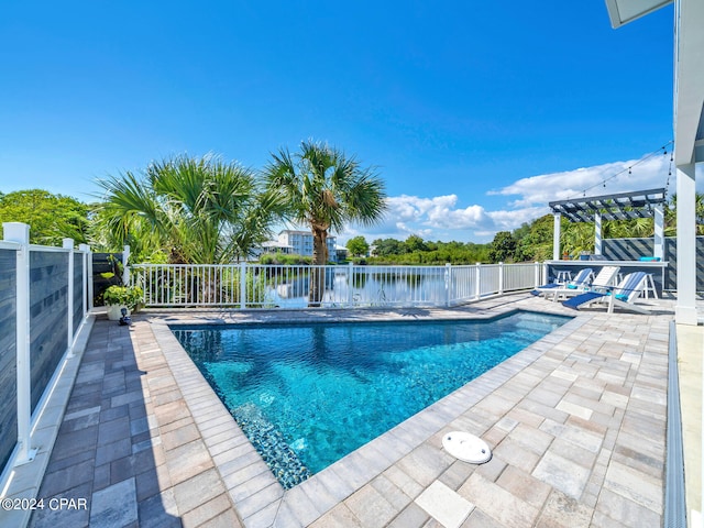 view of pool with a pergola, a water view, and a patio area