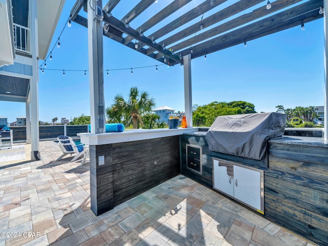 view of patio with exterior bar, a pergola, area for grilling, and a grill