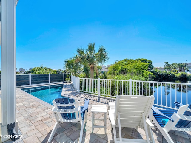 view of swimming pool featuring a patio area and a water view