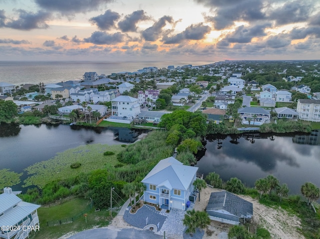 aerial view at dusk featuring a water view