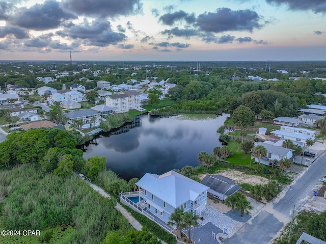 aerial view at dusk featuring a water view