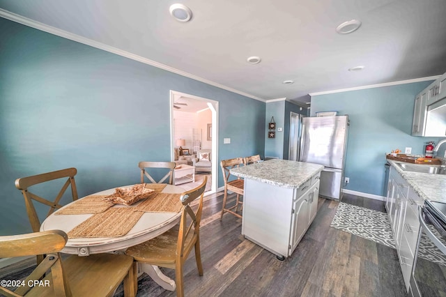 kitchen featuring stainless steel refrigerator, dark wood-type flooring, a kitchen island, sink, and stove