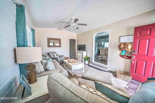 living room featuring crown molding, wood-type flooring, ceiling fan, and vaulted ceiling with beams