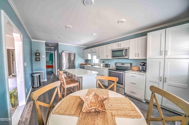 kitchen featuring white cabinets, stainless steel appliances, a kitchen island, and dark hardwood / wood-style flooring