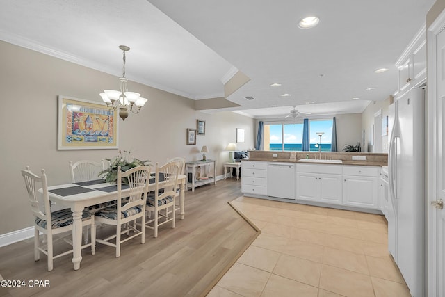 kitchen featuring white appliances, light wood-type flooring, ornamental molding, white cabinets, and sink