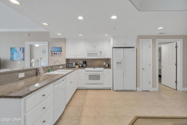 5004 Thomas Dr Unit 1209, Panama City Beach, FL 32408 - kitchen featuring a sink, white appliances, a peninsula, and white cabinetry