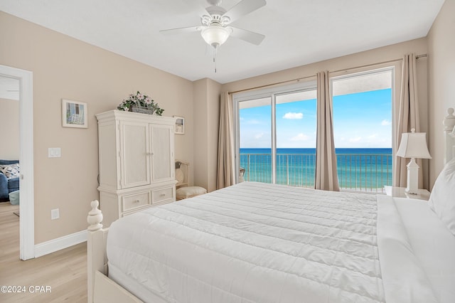 5004 Thomas Dr Unit 1209, Panama City Beach, FL 32408 - bedroom featuring light wood-type flooring, a water view, access to exterior, baseboards, and ceiling fan