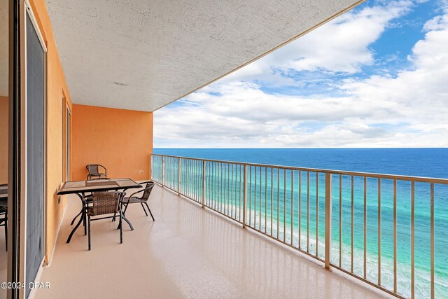 balcony featuring a water view and a beach view