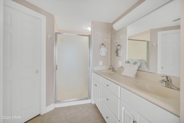 bathroom with walk in shower, vanity, and tile patterned flooring