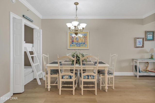 dining room featuring crown molding, a chandelier, and light wood-type flooring