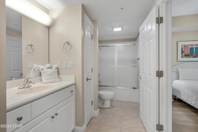 full bathroom featuring bath / shower combo with glass door, toilet, vanity, and tile patterned flooring