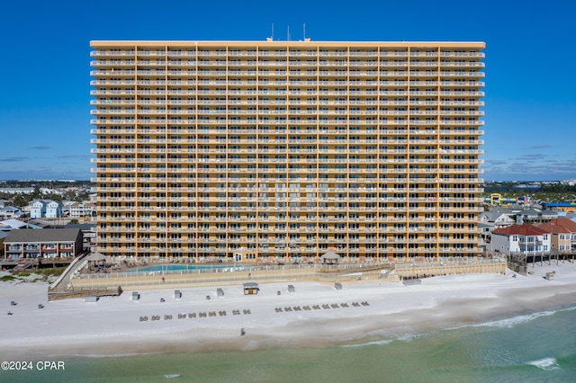 view of building exterior with a water view and a beach view