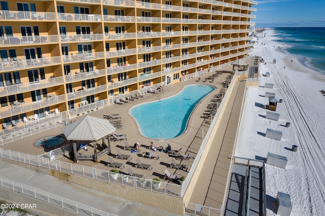 view of swimming pool featuring a view of the beach and a water view