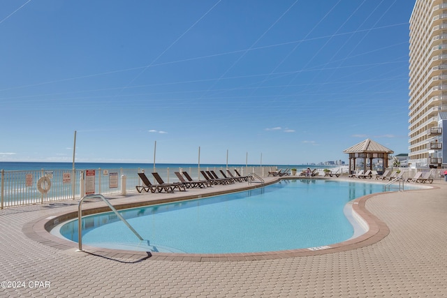 view of pool with a gazebo and a water view