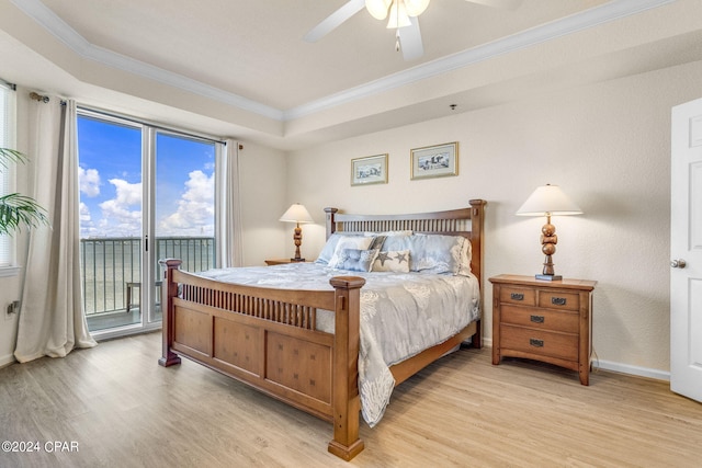 bedroom with access to exterior, ceiling fan, a tray ceiling, and light hardwood / wood-style flooring