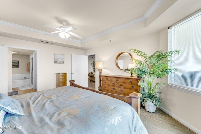 bedroom with a raised ceiling, ensuite bathroom, light hardwood / wood-style floors, and ceiling fan