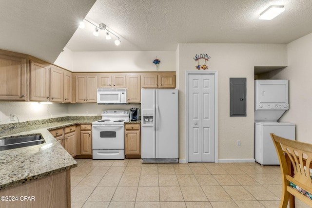 kitchen with light stone counters, a textured ceiling, white appliances, stacked washer / drying machine, and light tile flooring